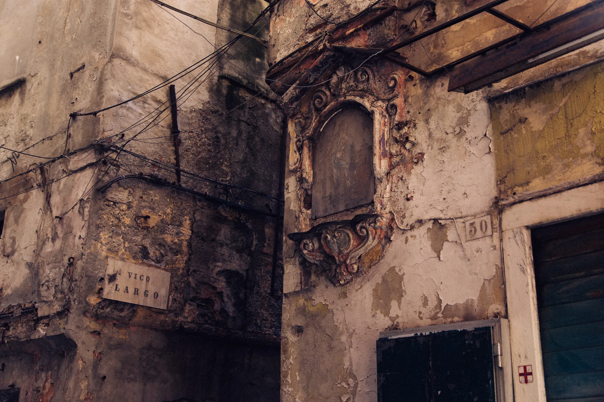 A worn palazzo facade with a weathered shrine